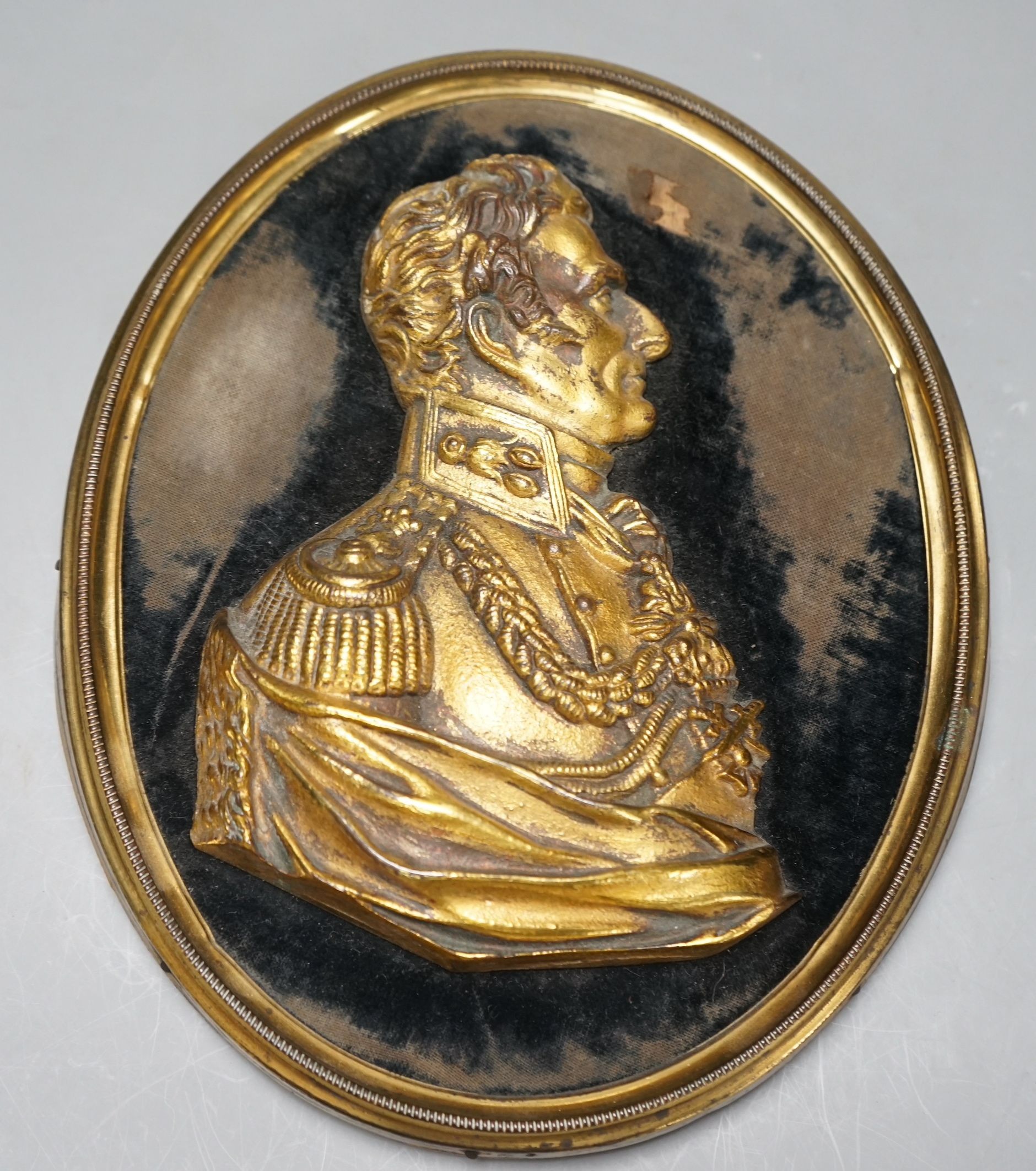 A gilt metal portrait profile relief, The Duke of Wellington, set on black velvet ground, brass frame, 23cms high